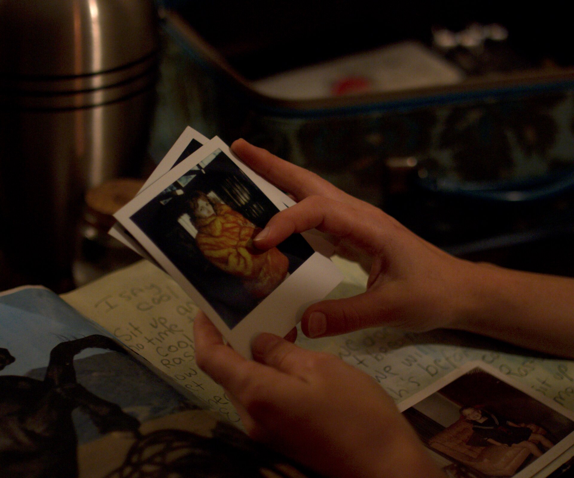 Nova holding polaroids of Nicola